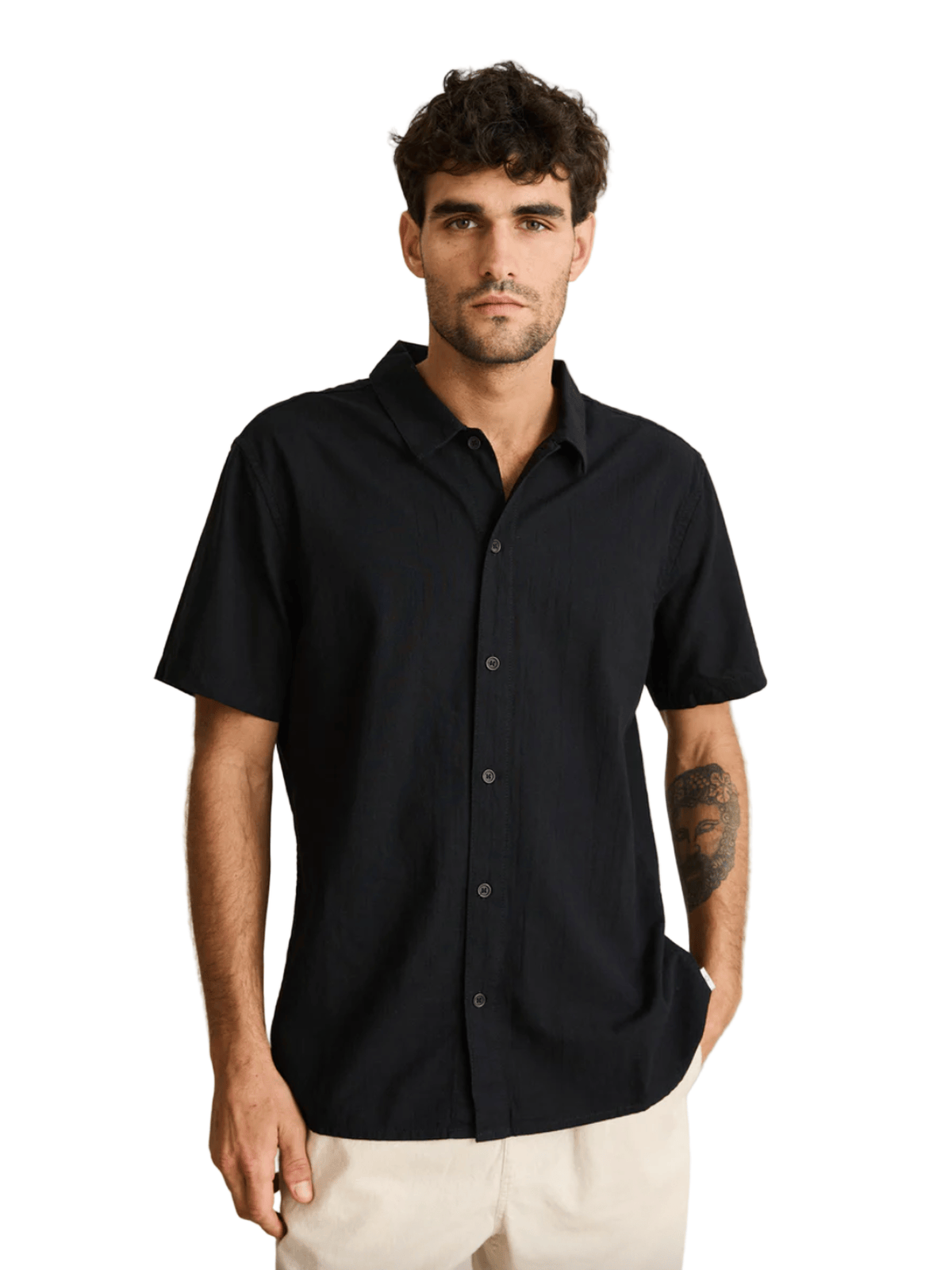 Man wearing a black short-sleeve shirt against a beige background