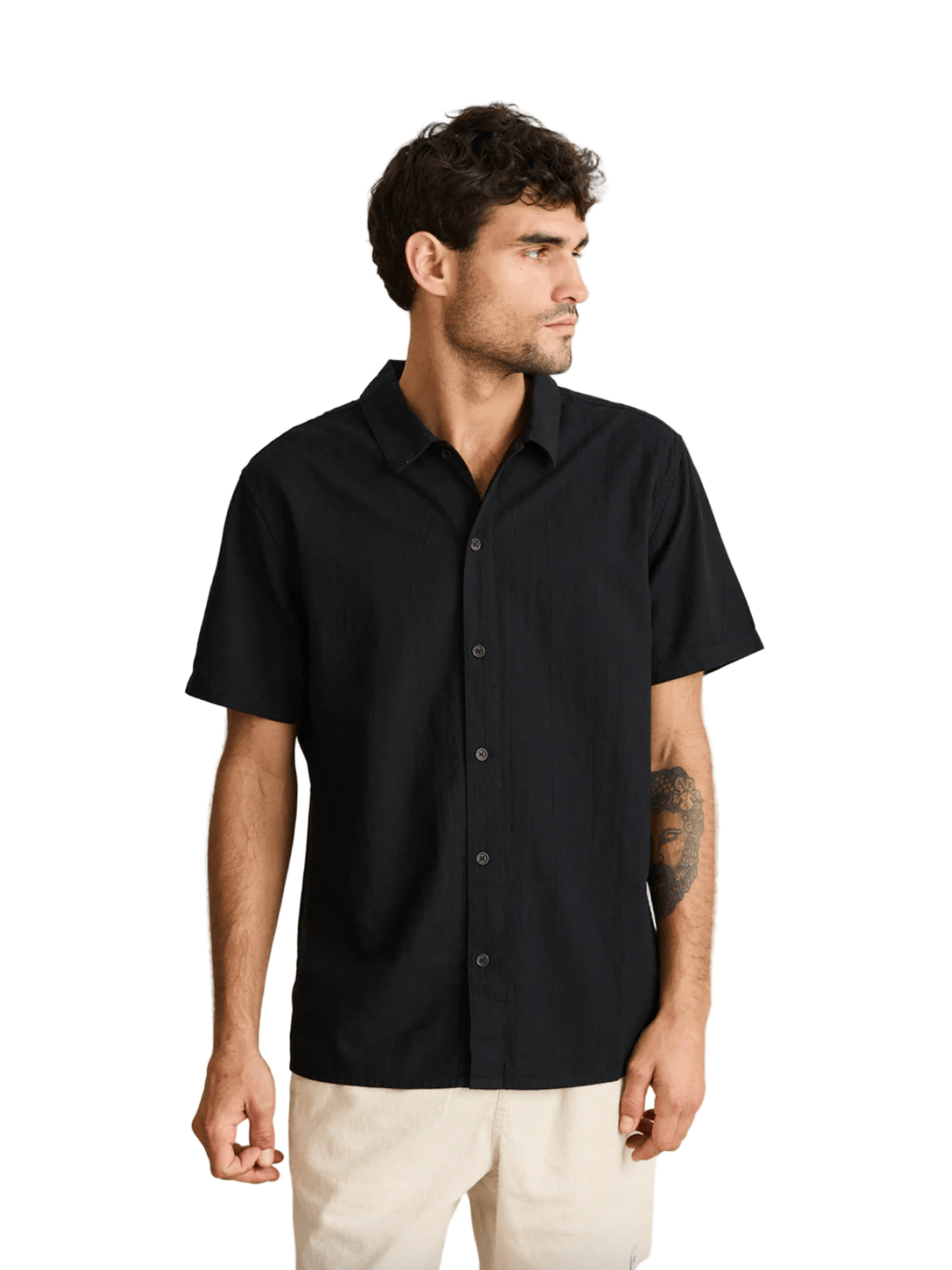 Man wearing a black short-sleeve shirt against a beige background
