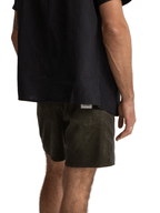 Person wearing black shirt and green shorts on a white background