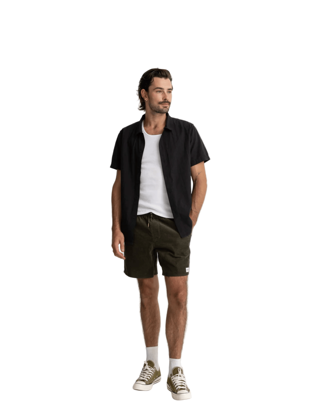 Man wearing a black shirt, white t-shirt, green shorts, and white sneakers on a white background