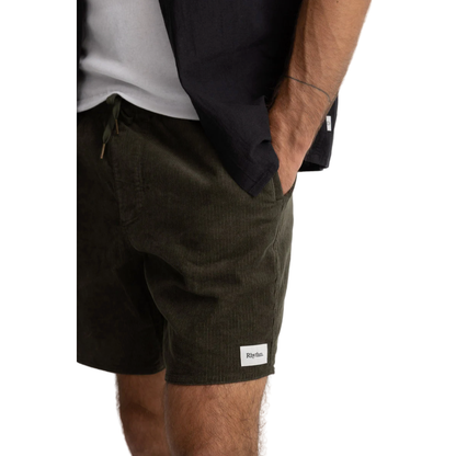 Person wearing black shorts with a visible brand logo on a white background