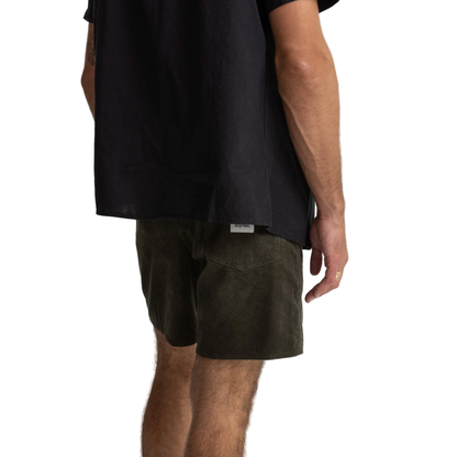 Person wearing black shirt and green shorts on a white background